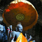 Who is it?  Angkor Wat was initially built as a hindu temple dedicated to Shiva, but was later converted into a buddhist temple. This statue looks like a crossbreed between Buddha and Shiva - whoever it is supposed to be, it certainly looked beautiful in the dusky light inside the temple