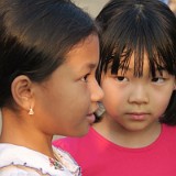 Clash of worlds  One girl selling postcards, the other daughter of asian tourist. They look so alike and yet live in different worlds.