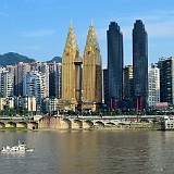 Dagobert Duck's Palace?  With a municipality's population of around 30 million, Chongqing one of the largest agglomerations in China, and it also must be one of the ugliest ones. This riverside section with it's two golden towers was quite impressive, though, and would be an apt home to Dagobert Duck. In reality it houses the Sheraton Hotel. The two black towers beside make it look a bit like heaven and hell.... (what the black towers are, I don't know)