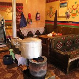 Tibetan Living Room  This is the typical setting in any Tibetan living room (and, as here, restaurant). As the buildings are poorly isolated and there is no heating system, the oven is located in the center of the room and daily life takes place around it. Because in the high altitudes, only few trees are growing and no wood is available for heating, the ovens are operated with dried yak droppings (which are readily available :-)