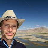 Cowboy?  No cowboy, but me with a (tibetan) cowboy hat - the girls of our tour group convinced me that this is the perfecct accessory for me :-)  In the back, some typical tibetan landscape unfolds, desert like, sandy and dry ground, despite the river running through it.