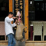 Attracting Customers - Yunnan Style  In the western countries, this marketing activity - to disembowel a goat at the entrance of a restaurant - certainly would not help to attract customers. Not sure if it worked here, either, as the place was empty at that time...