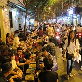 Hanoi Street Life 2  Whole of Vietnam passes the idle hours on stools no higher than 30 cm. Why that is, nobody was able to tell, but it's bloody uncomfortable. Beer prices are more comforting: a beer goes for 5000 Dong (0.25 CHF) and the food is cheap and yummie, too. The motorbikes, cars and pedesstrian almost stumbling over the stools and chairs are part of the fun and don't seem to disturb anyone.